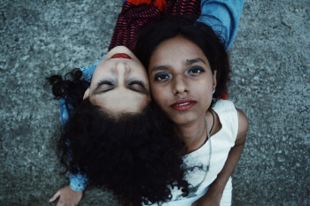 Two Women Sits on Gray Soil Taken Two Women Sits on Gray Soil Taken