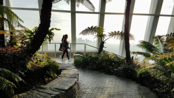 Two Women Walking Inside a Building With Garden Two Women Walking Inside a Building With Garden
