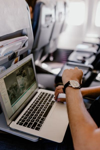 Unrecognizable man with notebook sitting inside an airplane Unrecognizable man with notebook sitting inside an airplane