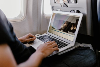 Unrecognizable man with notebook sitting inside an airplane Unrecognizable man with notebook sitting inside an airplane