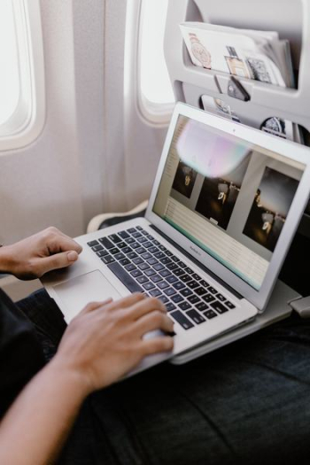 Unrecognizable man with notebook sitting inside an airplane Unrecognizable man with notebook sitting inside an airplane