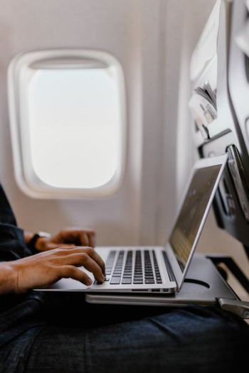 Unrecognizable man with notebook sitting inside an airplane Unrecognizable man with notebook sitting inside an airplane