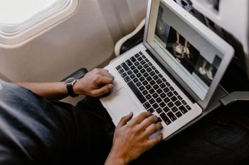 Unrecognizable man with notebook sitting inside an airplane Unrecognizable man with notebook sitting inside an airplane