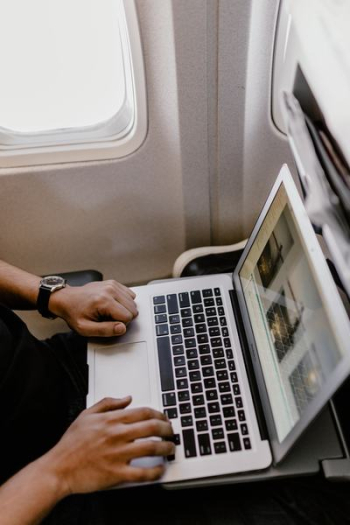 Unrecognizable man with notebook sitting inside an airplane Unrecognizable man with notebook sitting inside an airplane