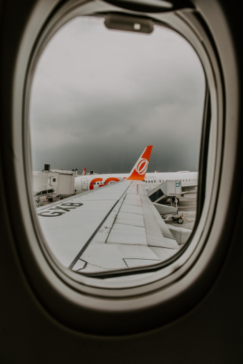 View of airplane wing through plane window View of airplane wing through plane window