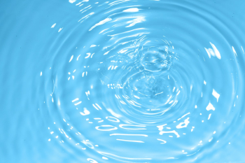 Water drop on clean blue water background Water drop on clean blue water background