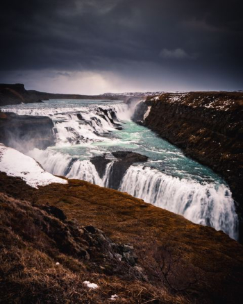 waterfalls under grey sky at daytime