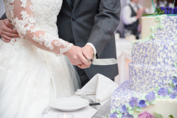 Wedding Couple Holding Knife While Cutting the Cake Wedding Couple Holding Knife While Cutting the Cake
