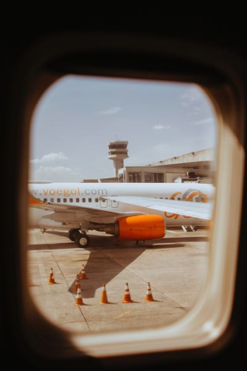 white and orange airplane through airplane window