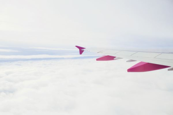 white and pink plane flying during daytime photography white and pink plane flying during daytime photography