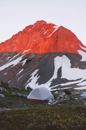 white and red camping tent near mountain white and red camping tent near mountain