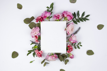 White blank paper on beautiful flowers over the white backdrop