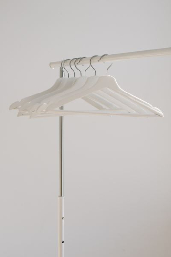 white clothes hangers hanging on rack white clothes hangers hanging on rack