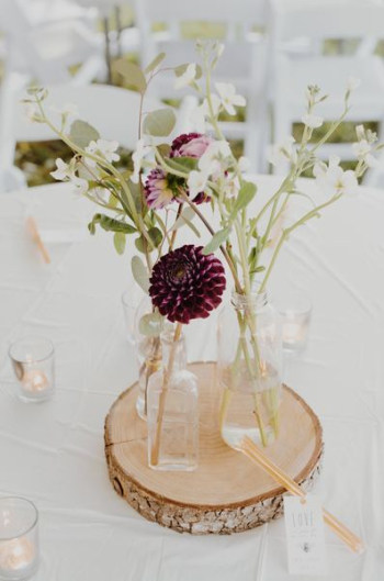white flower arrangement on glass bottle on tabletop white flower arrangement on glass bottle on tabletop