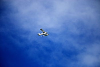 white flying biplane during white and blue sky white flying biplane during white and blue sky