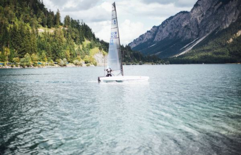 white sailboat on body of water white sailboat on body of water