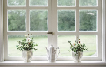 white teapot and tow flower vases on windowpane white teapot and tow flower vases on windowpane