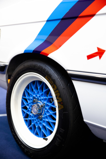 White Vehicle With Blue Multispoke Wheel and Tire White Vehicle With Blue Multispoke Wheel and Tire