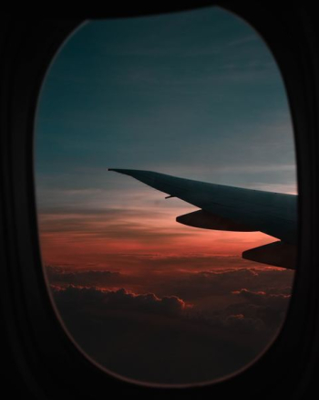 window view of airplane during golden hour window view of airplane during golden hour