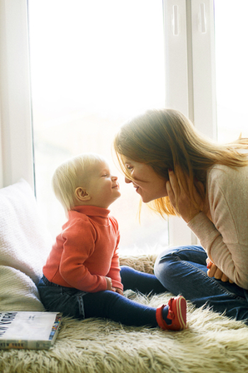 Woman And Child Sitting On Fur Covered Bed