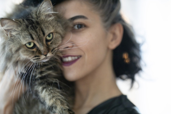 Woman Carrying Brown Tabby Cat Woman Carrying Brown Tabby Cat
