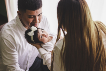 Woman Carrying Child in Front of Man Woman Carrying Child in Front of Man