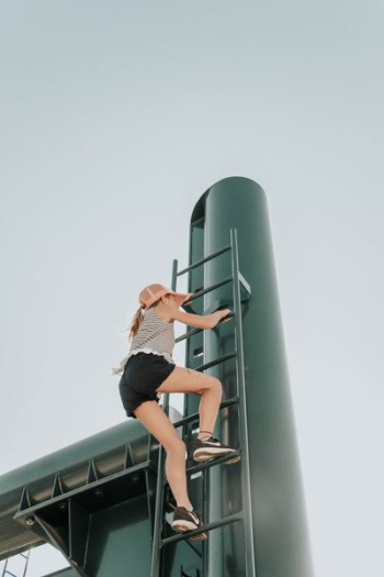 woman climbing ladder woman climbing ladder
