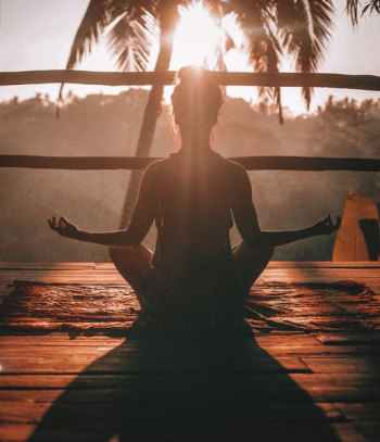woman doing yoga meditation on brown parquet flooring woman doing yoga meditation on brown parquet flooring