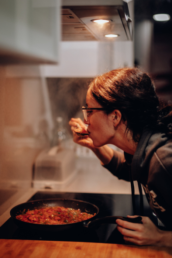 Woman Eating on Cooking Pan Woman Eating on Cooking Pan