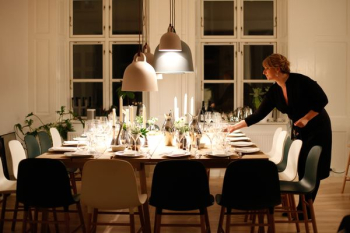 woman fixing dinnerware at table woman fixing dinnerware at table