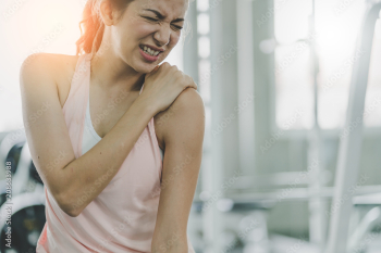 woman get accident between workout in gym shoulder pain and hurt with wrong posture  exercise