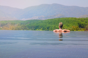 Woman Half Submerge Facing on Mountain