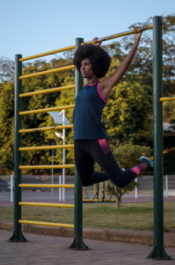 Woman Hanging on Climb Bar on Park Woman Hanging on Climb Bar on Park