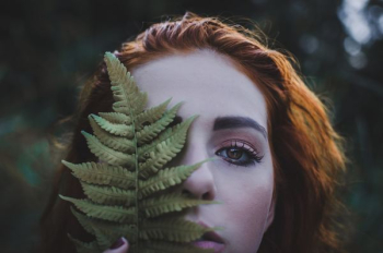 woman holding a green leaf at daytime