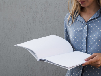 Woman holding a mock-up magazine Free Photo