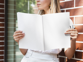 Woman holding a mock-up magazine Free Photo