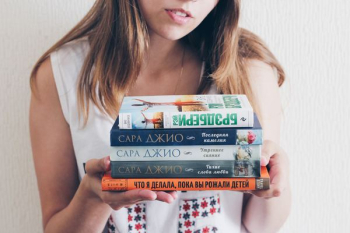 woman holding assorted books woman holding assorted books
