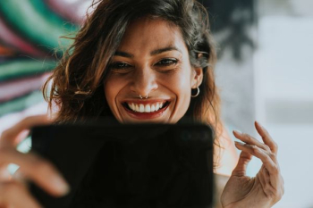 woman holding black Android smartphone woman holding black Android smartphone