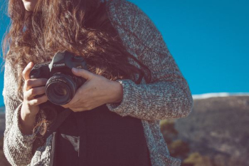 woman holding black Canon DSLR camera woman holding black Canon DSLR camera
