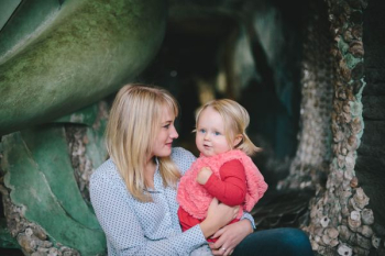 woman holding child while sitting down woman holding child while sitting down