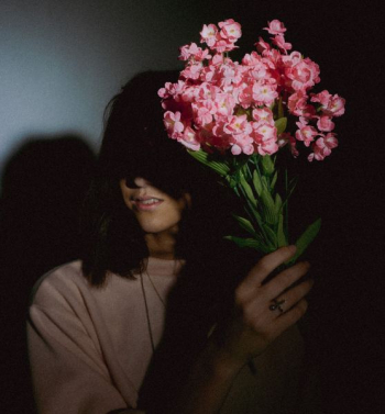 woman holding faux pink flower decors