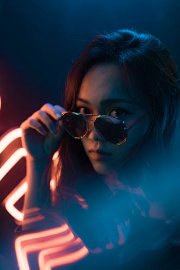 woman holding gold framed sunglasses woman holding gold framed sunglasses