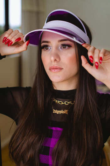 Woman Holding Her Purple and White Sun Visor Cap