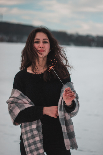 Woman Holding Lighted Sparkler on Snowfield Woman Holding Lighted Sparkler on Snowfield