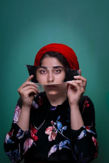 woman holding mirror shard woman holding mirror shard
