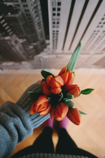 woman holding orange flowerbud bouquet woman holding orange flowerbud bouquet