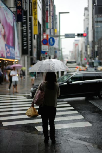 woman holding umbrella standing on pedestal lane woman holding umbrella standing on pedestal lane