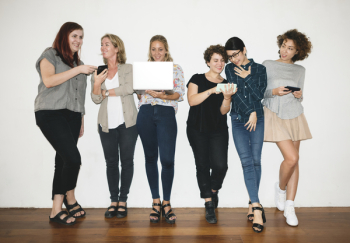 Woman Holding White Laptop Between Women Woman Holding White Laptop Between Women