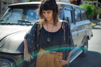 woman in black and pink open cardigan standing beside car during daytime