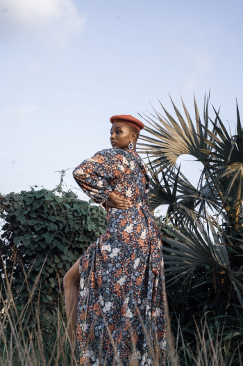 Woman in Black Floral Dress Standing on Field